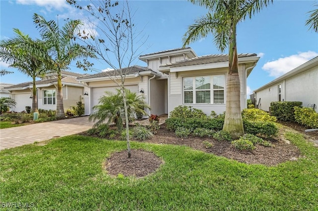 view of front of property with a garage, a front lawn, and decorative driveway