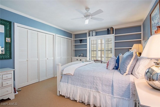 bedroom with crown molding, two closets, a ceiling fan, and light colored carpet