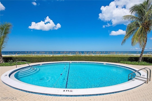 community pool featuring a beach view and a water view