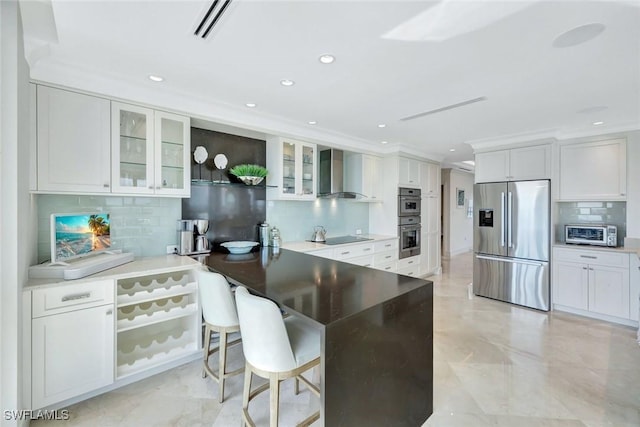 kitchen featuring stainless steel appliances, visible vents, glass insert cabinets, wall chimney range hood, and a peninsula