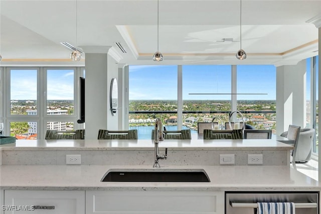 kitchen featuring light stone counters, plenty of natural light, and a sink