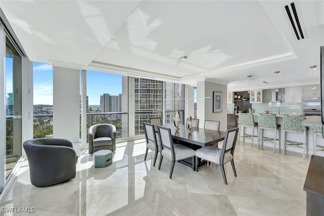 dining area featuring marble finish floor, a tray ceiling, a city view, and floor to ceiling windows