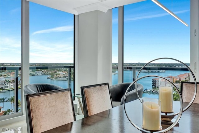 dining area with expansive windows and a water view