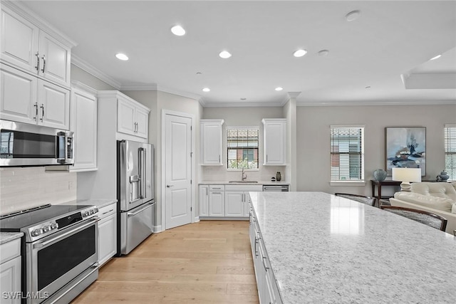 kitchen with appliances with stainless steel finishes, white cabinets, and a sink