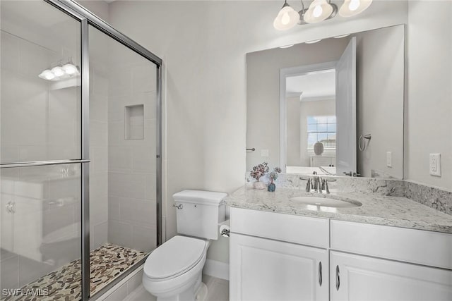 bathroom with vanity, a shower stall, and toilet