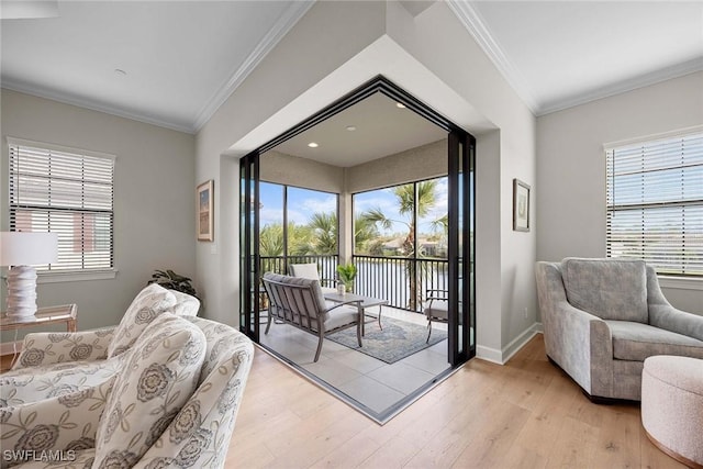 living area with ornamental molding, light wood finished floors, and a healthy amount of sunlight