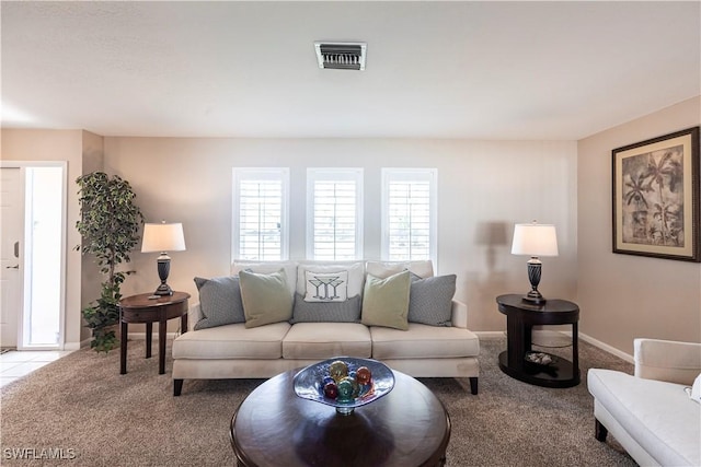 living room featuring light carpet, visible vents, and baseboards