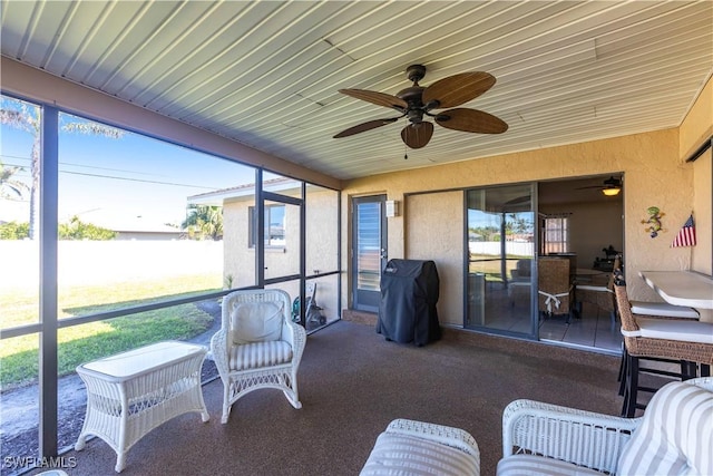 sunroom / solarium featuring a ceiling fan