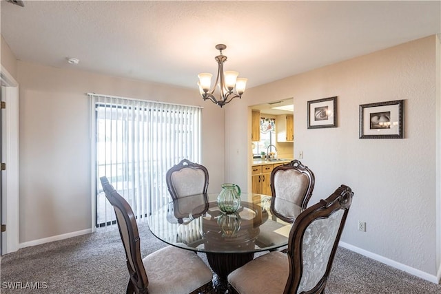 carpeted dining room with a chandelier, a sink, and baseboards