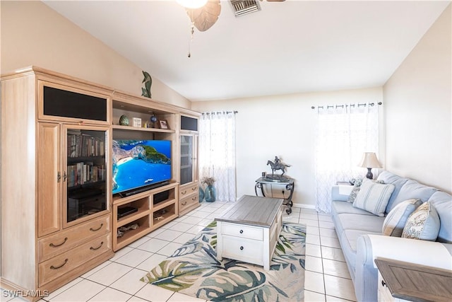 living room featuring lofted ceiling, light tile patterned floors, visible vents, and a ceiling fan