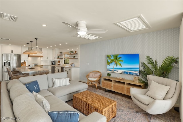 living area with a ceiling fan, recessed lighting, visible vents, and wallpapered walls