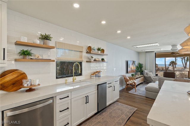 kitchen with a sink, light stone counters, open shelves, and stainless steel dishwasher