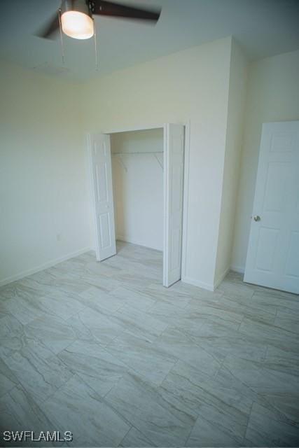 unfurnished bedroom with ceiling fan, baseboards, and a closet