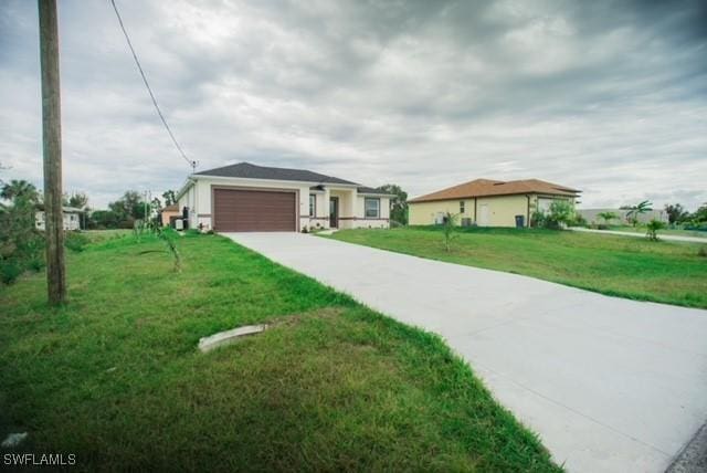 view of front of property featuring a garage, a front yard, and driveway