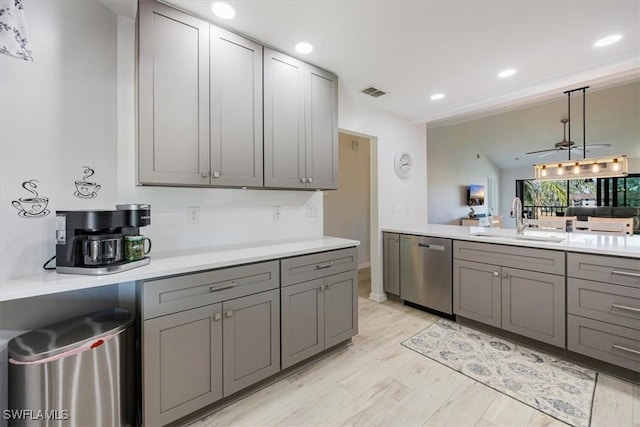 kitchen with gray cabinets, light countertops, visible vents, stainless steel dishwasher, and a sink