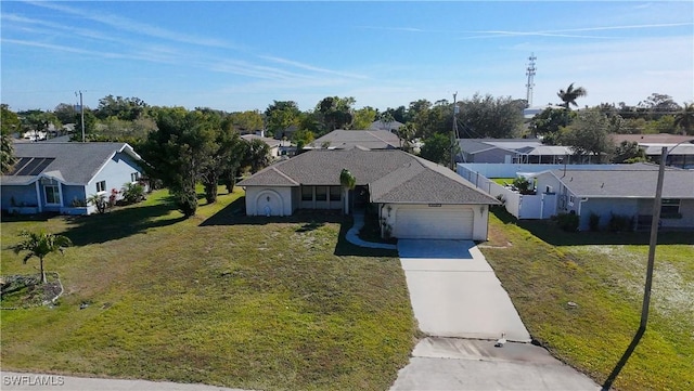 ranch-style home with a residential view, driveway, an attached garage, and a front yard