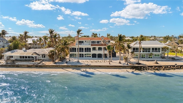 back of property featuring a water view and a view of the beach