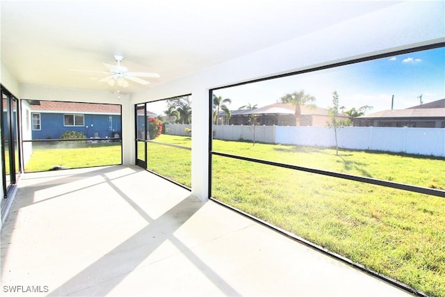 unfurnished sunroom featuring ceiling fan