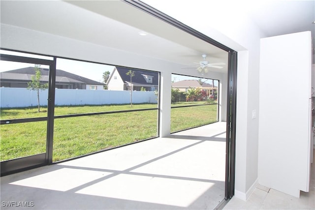 doorway to outside featuring ceiling fan and baseboards