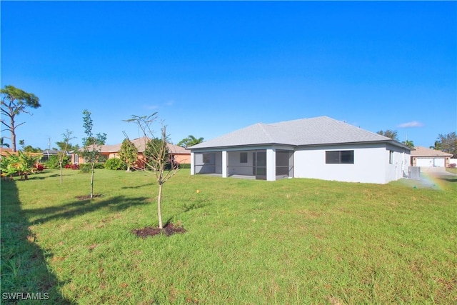 back of property with a sunroom and a yard