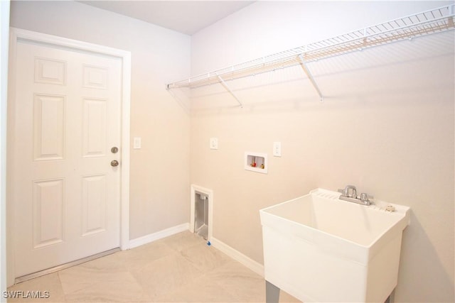 washroom with laundry area, washer hookup, light tile patterned flooring, and a sink