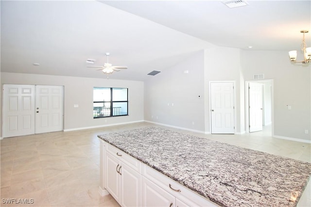 kitchen with visible vents, open floor plan, decorative light fixtures, light stone countertops, and white cabinetry