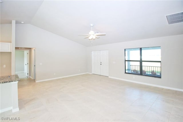 empty room with lofted ceiling, visible vents, ceiling fan, and baseboards