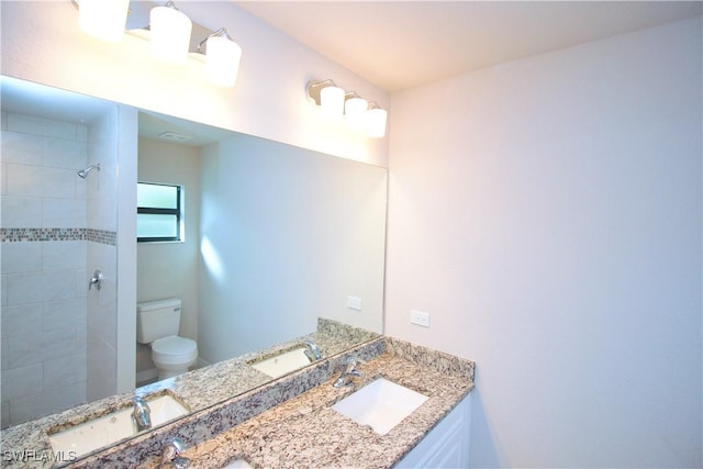 full bathroom featuring a sink, toilet, and double vanity