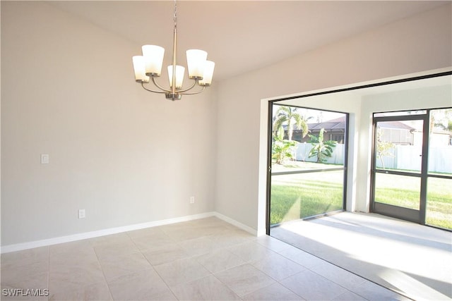 spare room featuring a wealth of natural light, a notable chandelier, baseboards, and light tile patterned floors