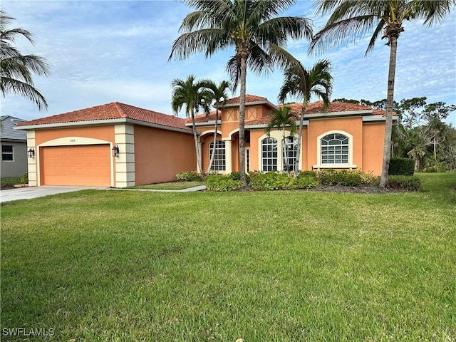 mediterranean / spanish home featuring a garage, driveway, a front lawn, and stucco siding