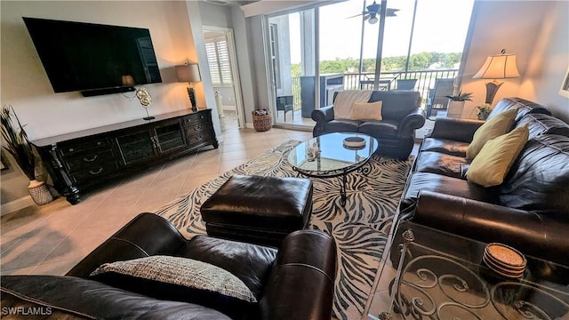 living room featuring light tile patterned floors, ceiling fan, and baseboards