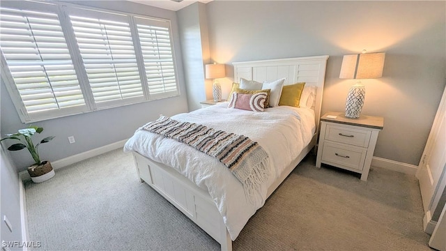 bedroom featuring baseboards and light colored carpet