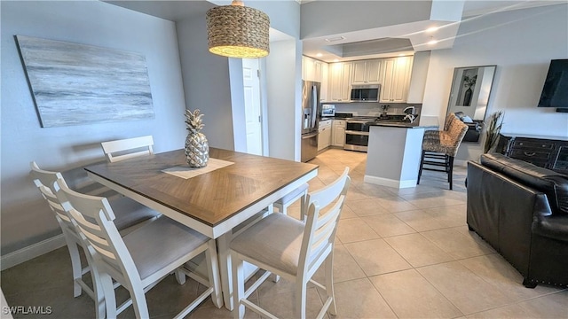 dining room featuring light tile patterned floors and baseboards