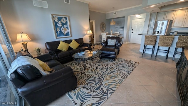 living room with visible vents, crown molding, and light tile patterned flooring