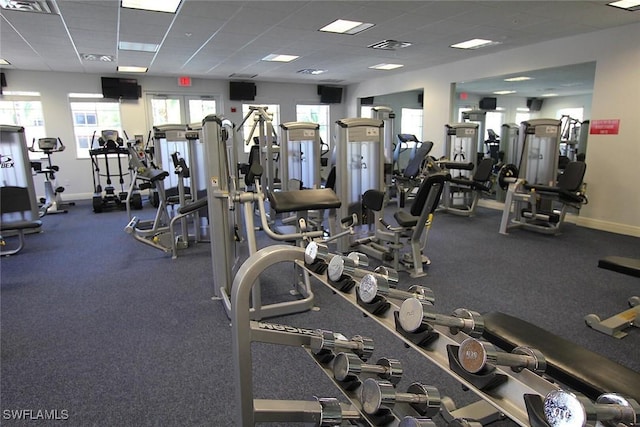 exercise room featuring a paneled ceiling, visible vents, and baseboards