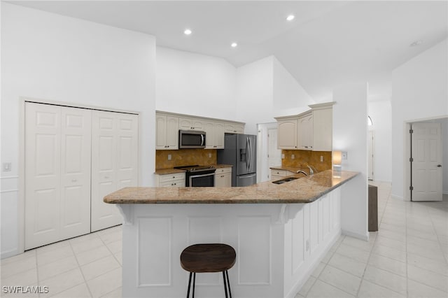 7735 Citrus Hill Ln, Naples, FL 34109 - kitchen with appliances with stainless steel finishes, a peninsula, light tile patterned floors, backsplash, and high vaulted ceiling