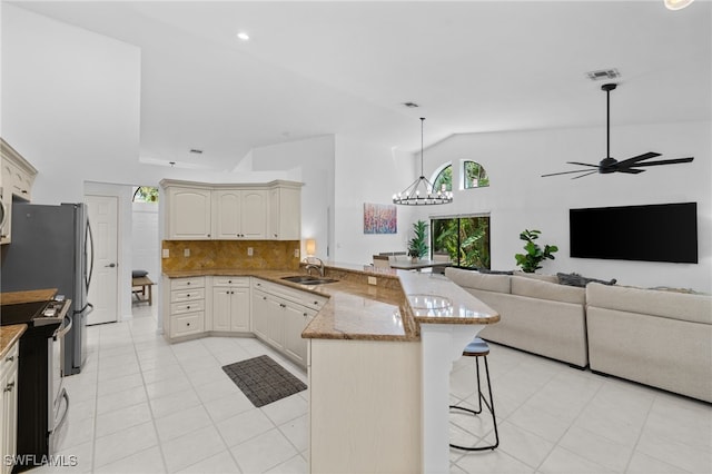 7735 Citrus Hill Ln, Naples, FL 34109 - kitchen featuring a sink, a peninsula, stainless steel appliances, a breakfast bar area, and light tile patterned floors
