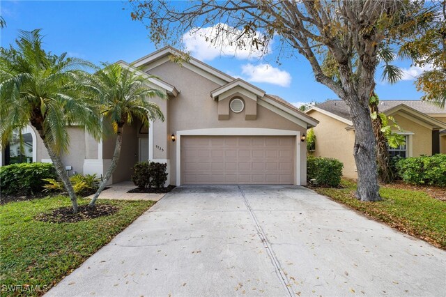 7735 Citrus Hill Ln, Naples, FL 34109 - view of front of house with stucco siding, driveway, and an attached garage