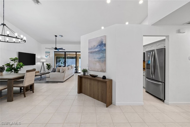 7735 Citrus Hill Ln, Naples, FL 34109 - living area featuring a chandelier, ceiling fan, light tile patterned floors, vaulted ceiling, and baseboards