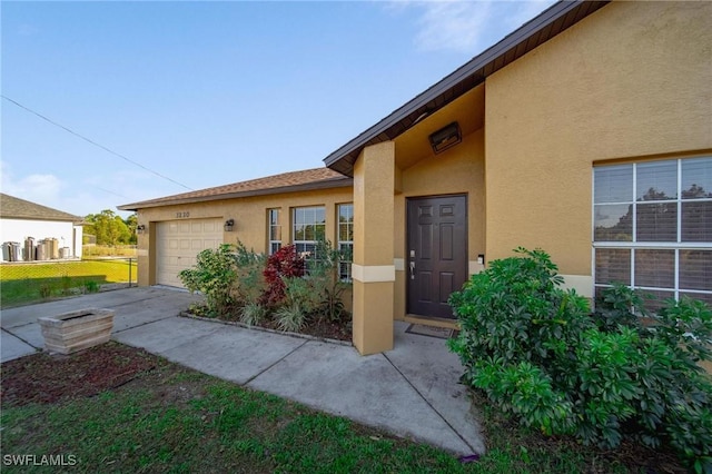 property entrance featuring a garage and stucco siding