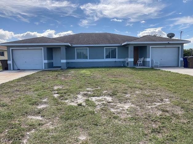 single story home featuring a front yard, driveway, an attached garage, and stucco siding