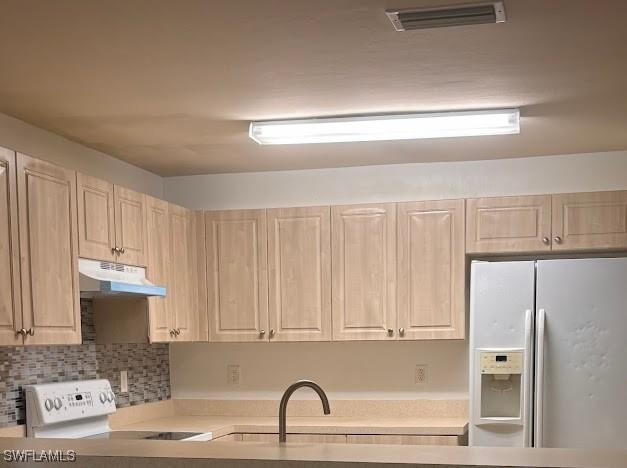 kitchen featuring visible vents, electric stove, fridge with ice dispenser, light countertops, and under cabinet range hood