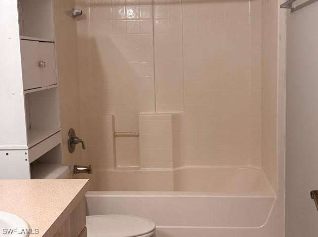 bathroom featuring toilet, vanity, and shower / tub combination