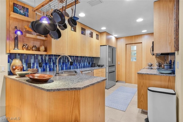 kitchen featuring visible vents, appliances with stainless steel finishes, a sink, light stone countertops, and backsplash