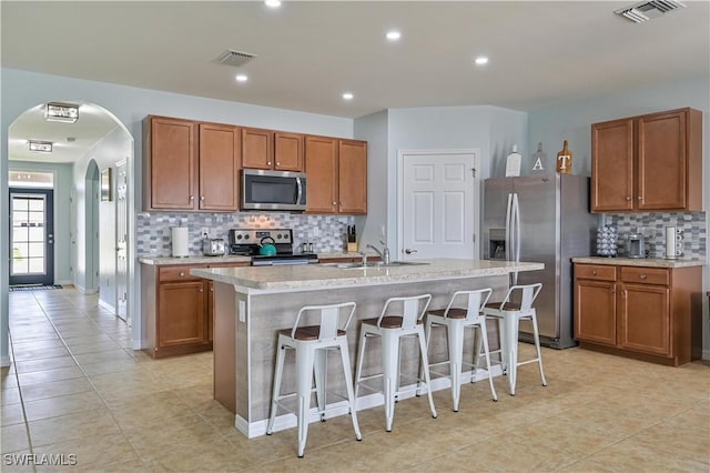 kitchen featuring an island with sink, visible vents, appliances with stainless steel finishes, and light countertops