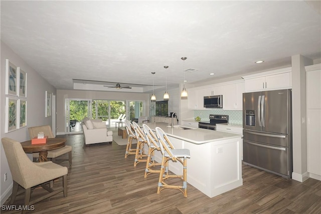 kitchen featuring a sink, stainless steel appliances, light countertops, white cabinetry, and backsplash