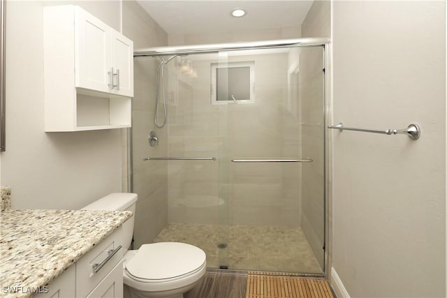 full bath featuring vanity, a shower stall, and toilet