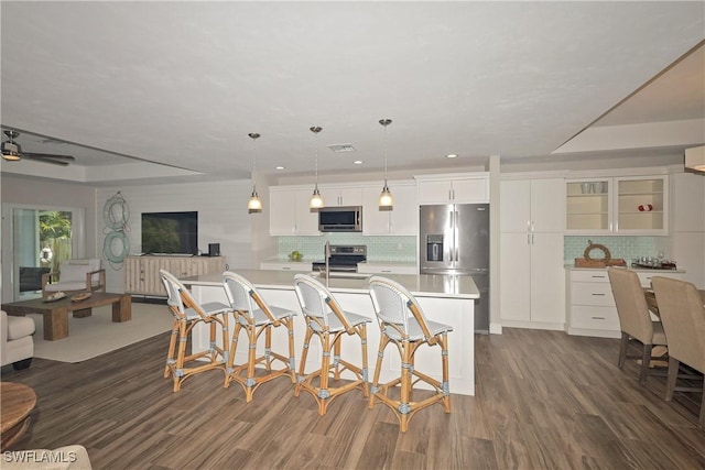 kitchen featuring stainless steel appliances, dark wood-style flooring, light countertops, and white cabinets