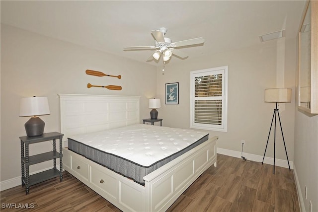 bedroom featuring dark wood-type flooring, a ceiling fan, and baseboards