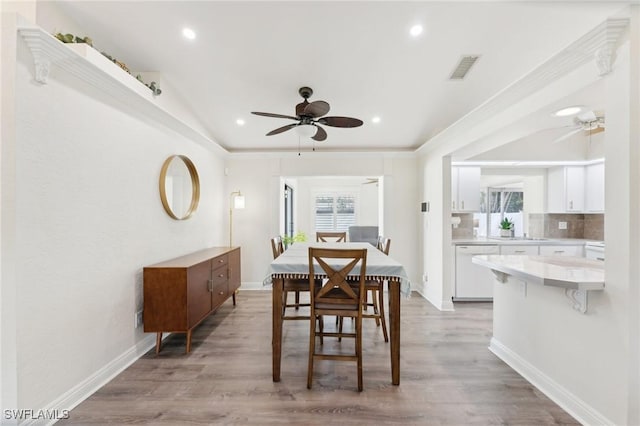 dining room featuring visible vents, ceiling fan, and light wood finished floors